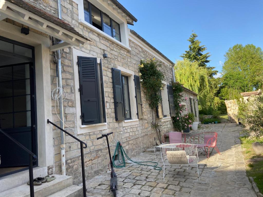 une terrasse avec une table et des chaises devant un bâtiment dans l'établissement Cocon en lisière de forêt, à Bourron-Marlotte