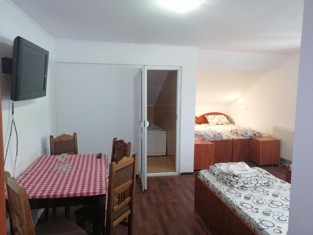a room with a table and a bed and a table and chairs at vila elly in Piatra Neamţ