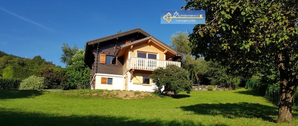 una casa en un campo verde con un árbol en MOUFFLON, en Verchaix