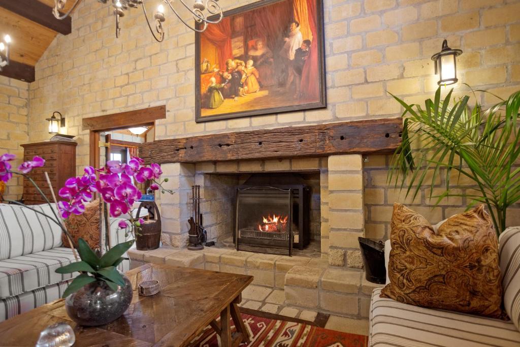 a living room with a fireplace with a painting at Villa Casa Maria Luxury Farmhouse in Katikati