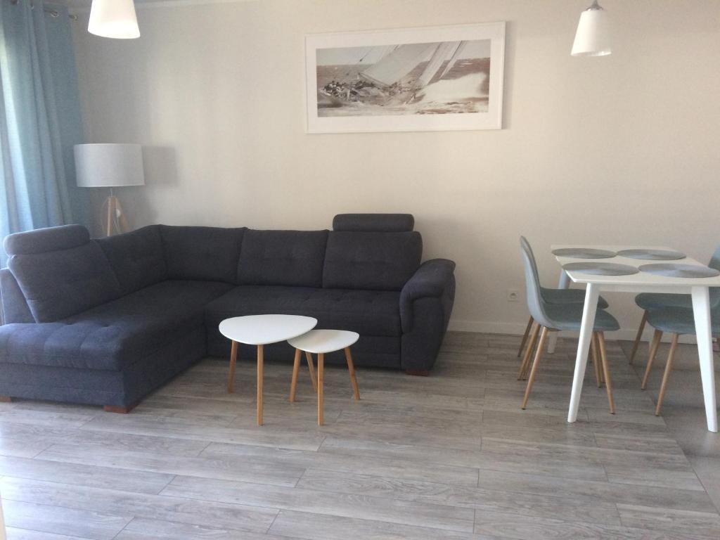 a living room with a couch and tables and chairs at Apartament 44 Pogo in Pogorzelica