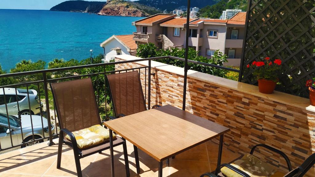 een balkon met een tafel en stoelen en de oceaan bij Apartments Abramovic 2 in Sutomore