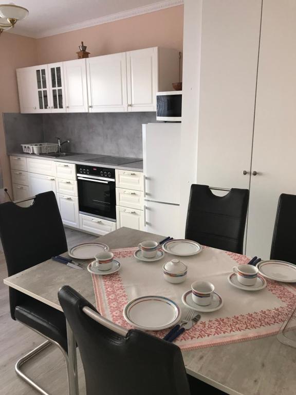 a kitchen with a table with plates and chairs at Wohnen mitten in Oberhausen, Nähe Centro in Oberhausen