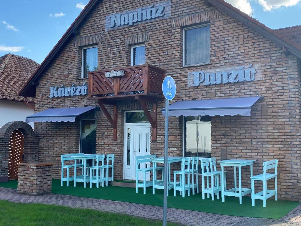 um restaurante com mesas e cadeiras fora dele em Napház Panzió em Tiszafüred