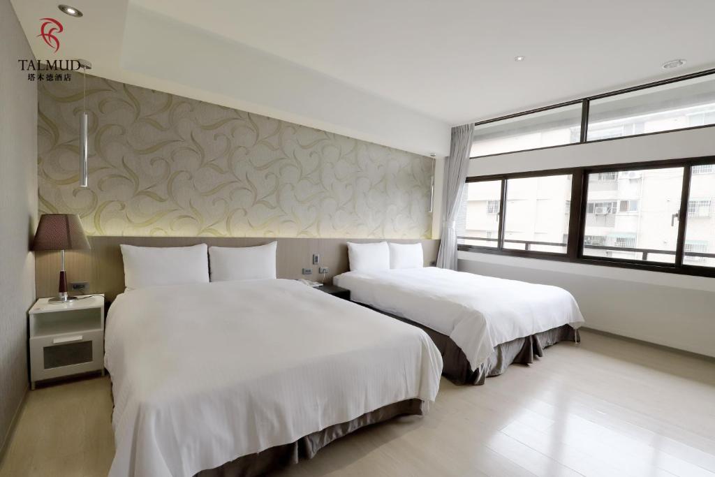 a hotel room with two beds and a window at Talmud Hotel Taichung in Taichung