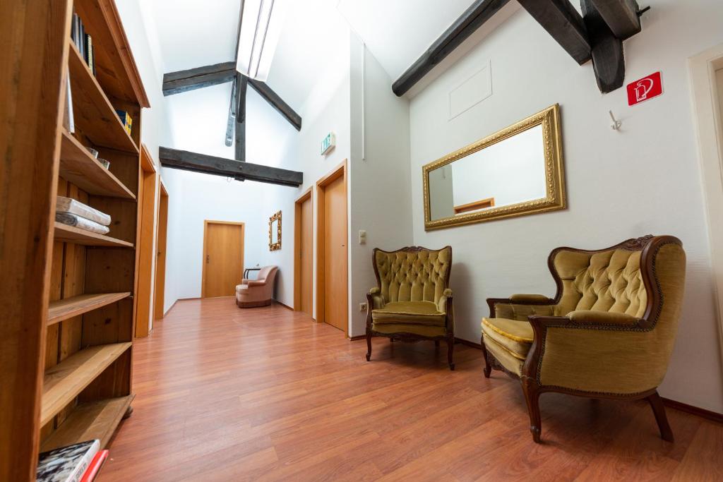 a hallway with two chairs and a mirror at Burer Millen, Born Mühle in Born