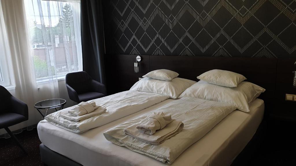 Postel nebo postele na pokoji v ubytování Vácz Hotel