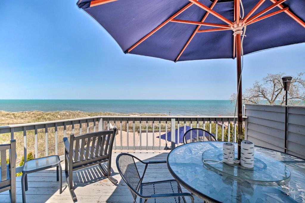 une terrasse avec une table, des chaises et un parasol dans l'établissement Lakefront Family Retreat with Grill Steps to Beach!, à Gary