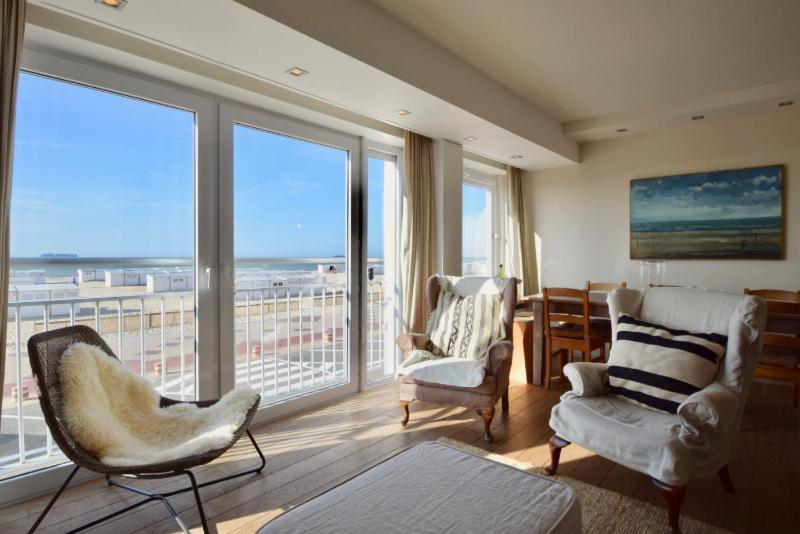 a living room with two chairs and a large window at Apartment Entre Ciel et Mer in Knokke-Heist