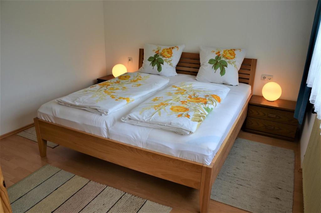 Bett in einem Zimmer mit zwei Kissen darauf in der Unterkunft Ferienwohnung Walgaublick in Frastanz