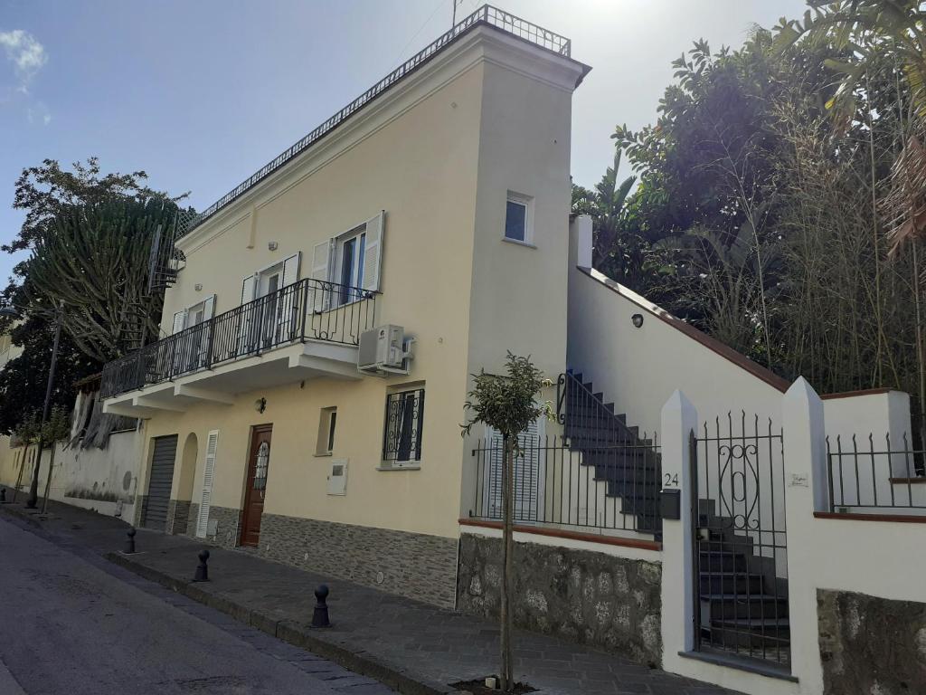 a white building with a staircase on the side of a street at Da Raff house in Lacco Ameno