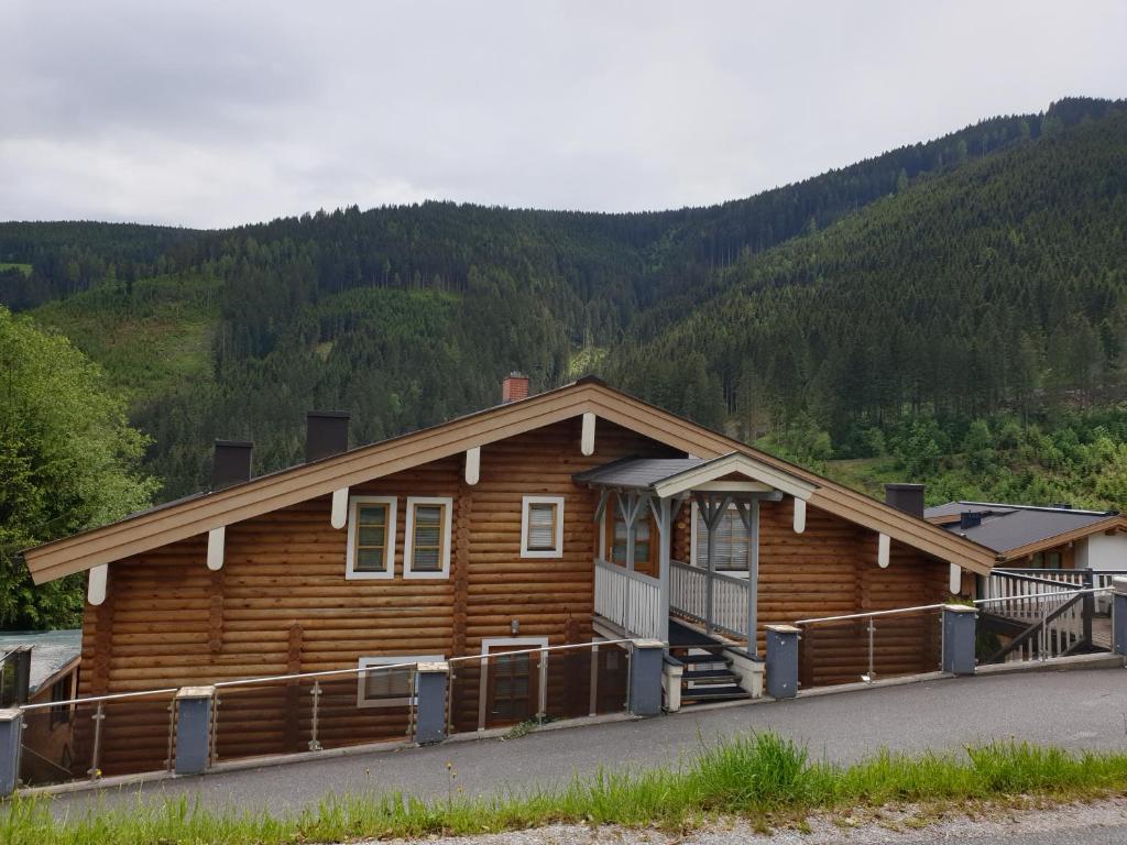 une cabane en rondins avec une montagne en arrière-plan dans l'établissement Chalet Berni, à Zell am See