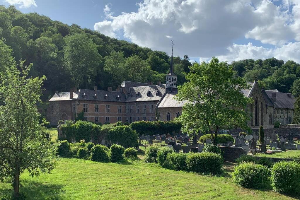 un grande edificio con un cimitero di fronte di Abbaye Notre-Dame du Vivier - Le Bief du Vivier a Namur