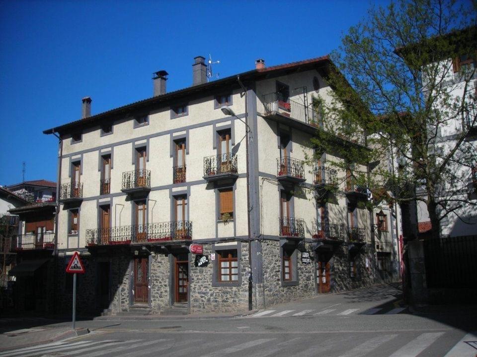 ein großes weißes Gebäude mit Balkon auf einer Straße in der Unterkunft Apartamento rural Casa Arritxenea in Leitza