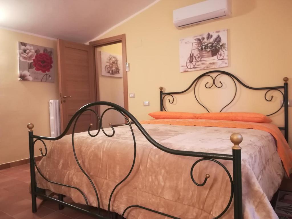 ein Schlafzimmer mit einem großen Bett mit orangefarbener Bettwäsche in der Unterkunft la corta di spello camere in Spello