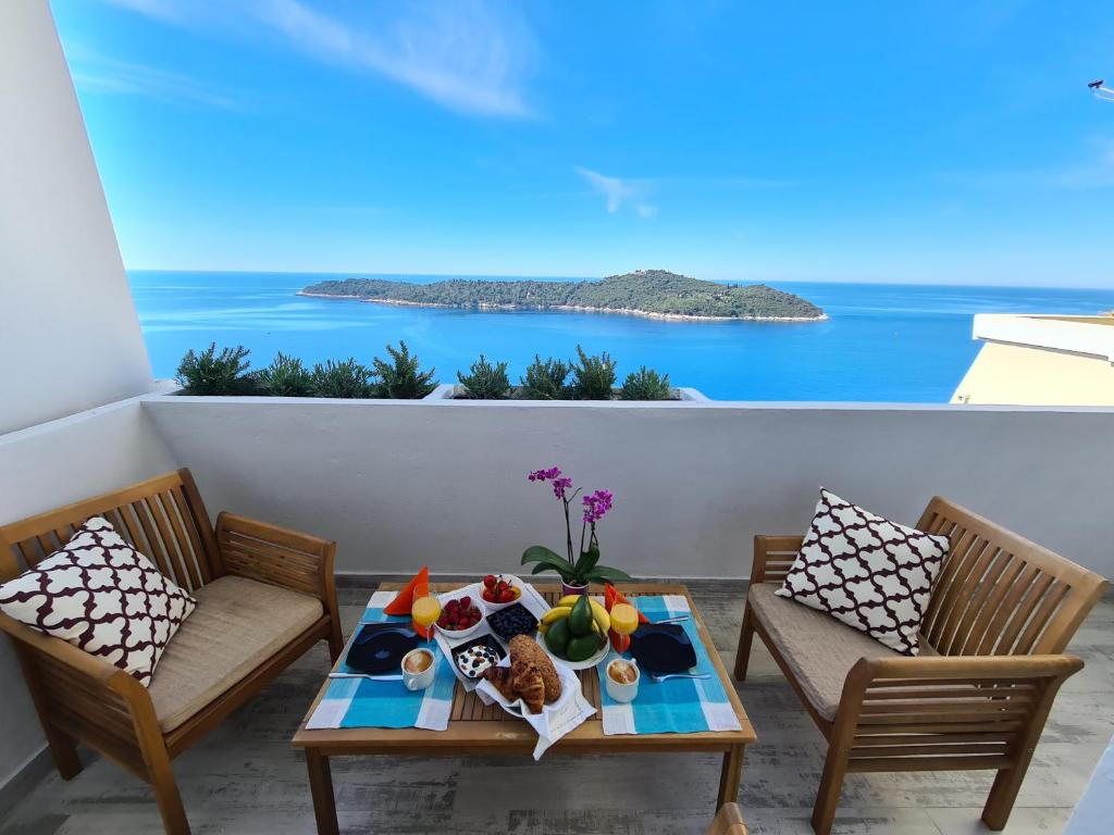 a table on a balcony with a view of the ocean at Lacroma Apartment in Dubrovnik