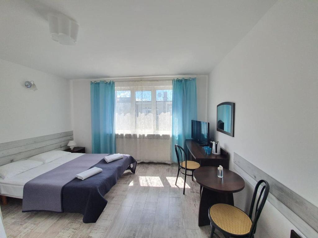 a hotel room with a bed and a table and chairs at Villa Marbela in Ustka