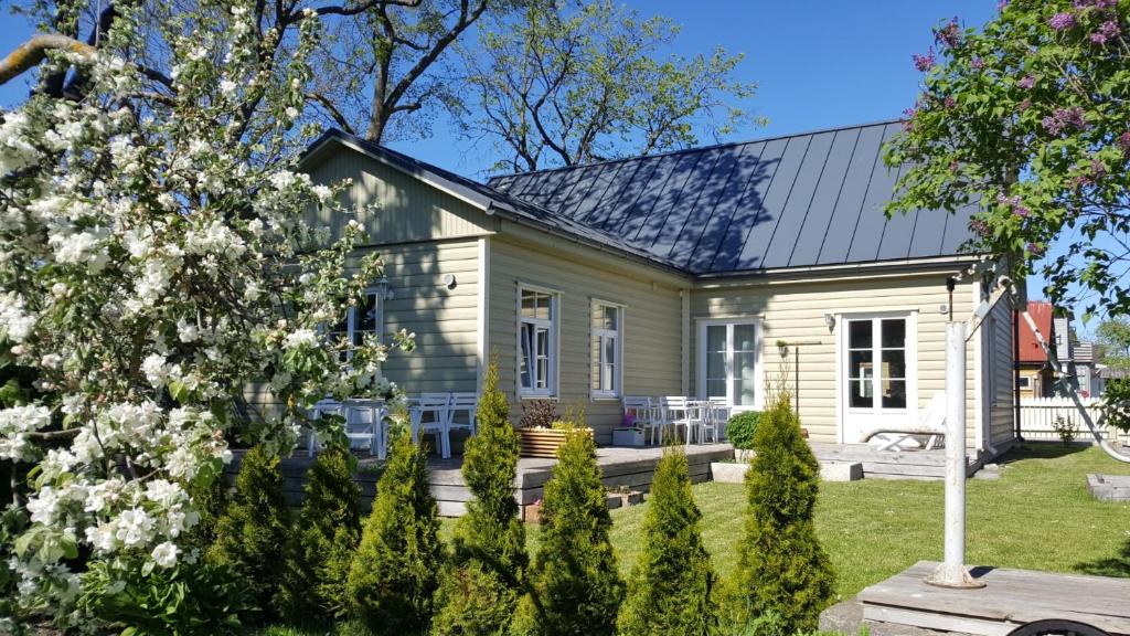 a small white house with a porch at Kuressaare Family and Garden Apartments in Kuressaare