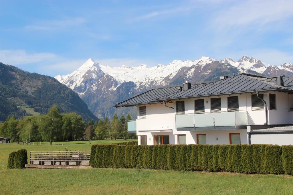 a white house with mountains in the background at Appartements Julia in Zell am See