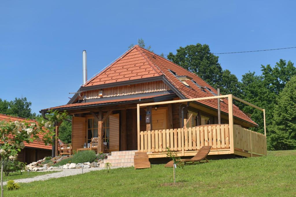 a log cabin with a porch and chairs in a yard at Kuća za odmor Markoci in Rakovica