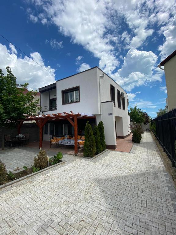 a white house with a patio and a fence at Vila Ammos Mamaia 120 Metri De Plaja in Mamaia Sat/Năvodari