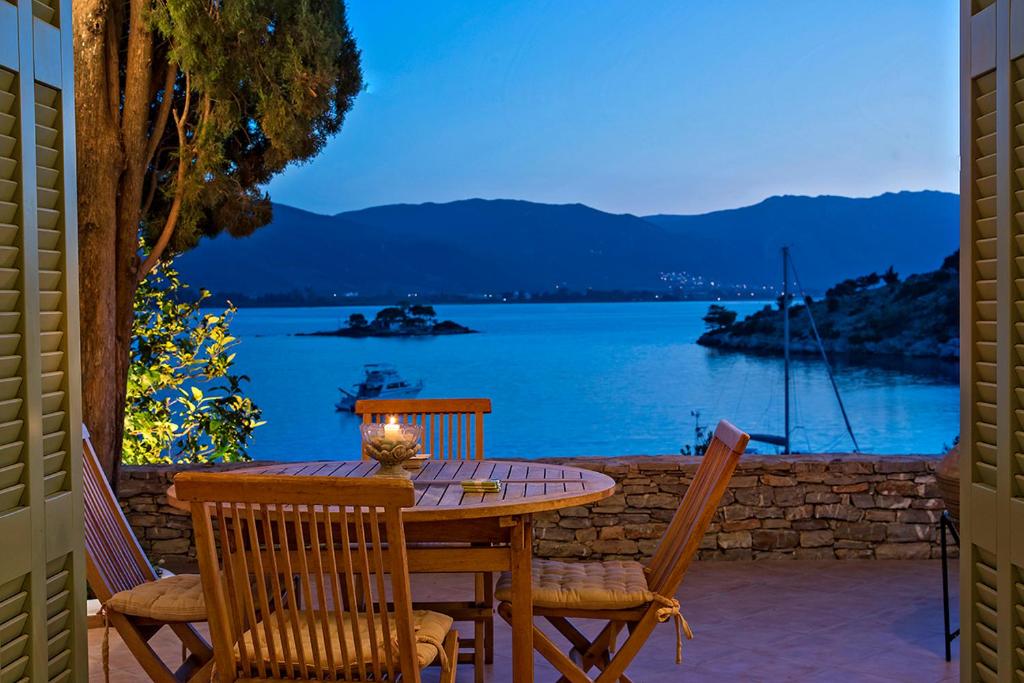 una mesa y sillas con vistas al lago en Unique Villa on the Island of Poros en Poros