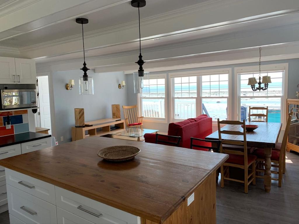 a kitchen and living room with a table and chairs at Chalet chez les Petit in Grandes-Bergeronnes