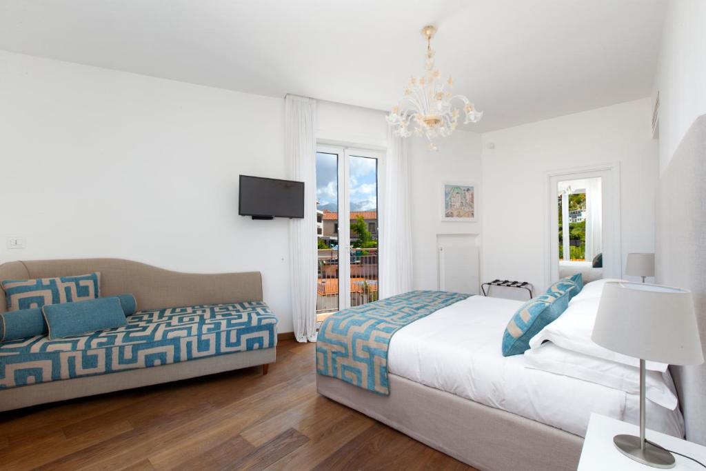 um quarto branco com 2 camas e um lustre em Luxury Home Sea View & Jacuzzi in Sorrento centre em Sorrento