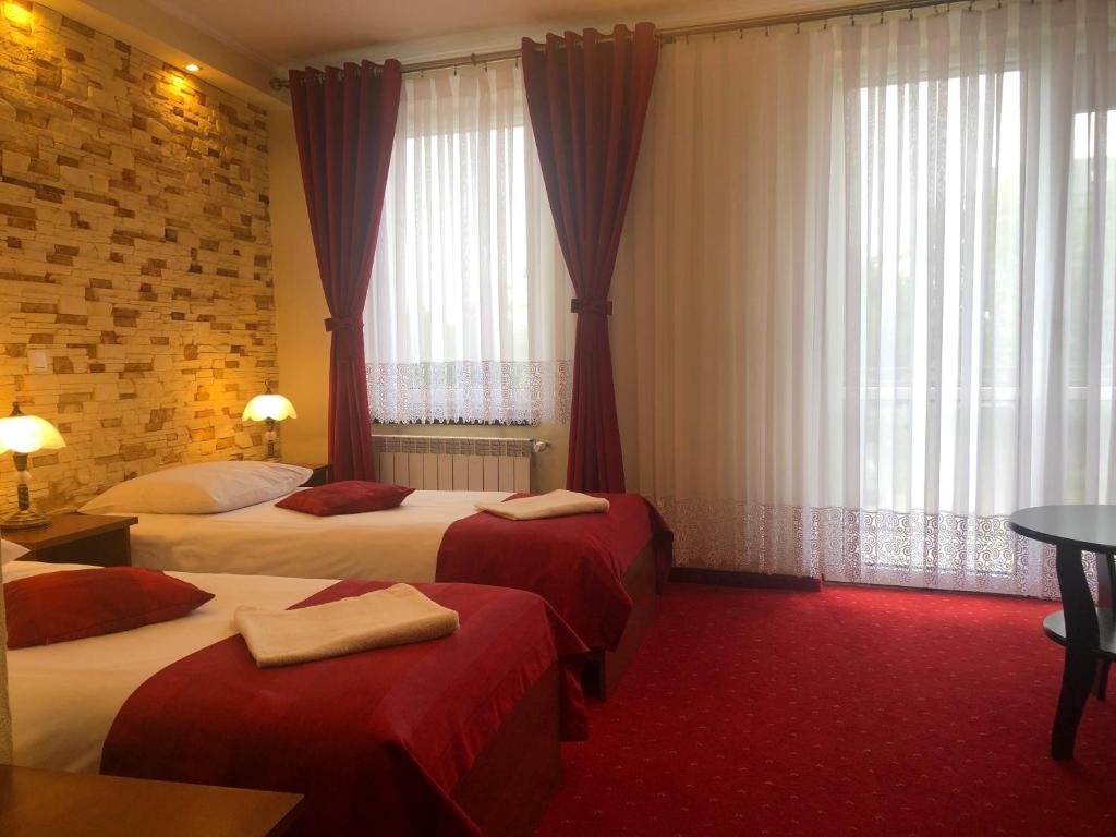 チェンストホヴァにあるHotel Sekwanaのベッド2台と窓が備わるホテルルームです。