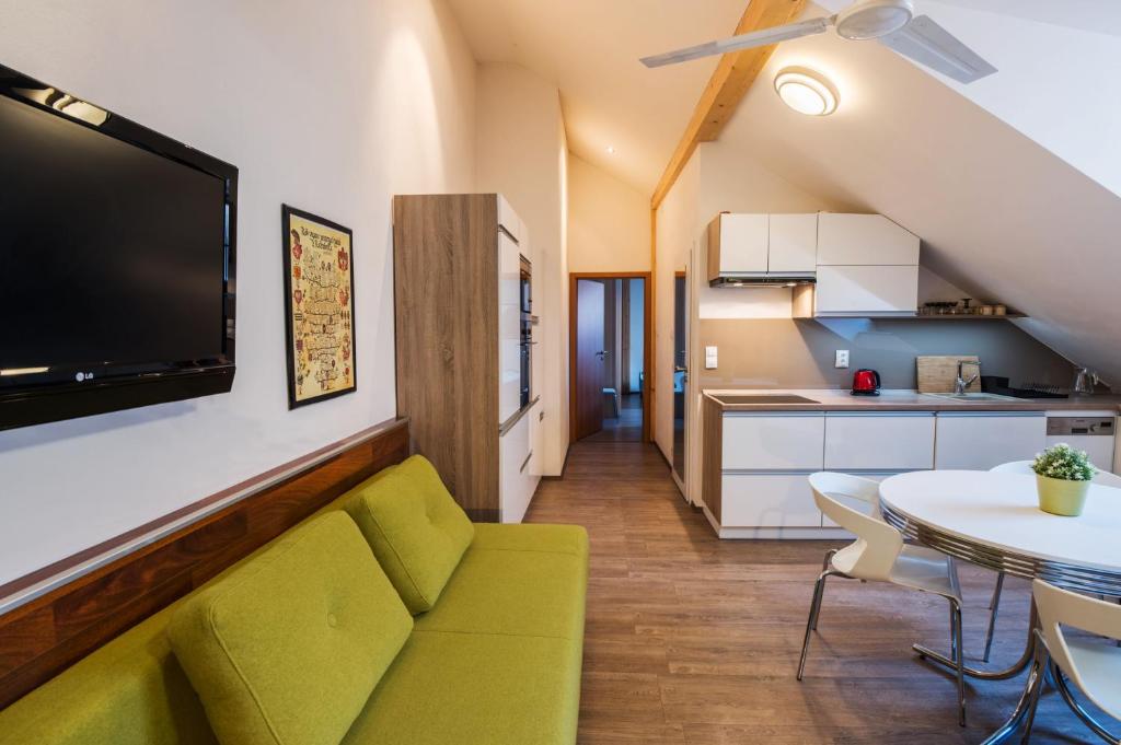 a living room with a green couch and a table at Apartman Masne kramy in Třeboň