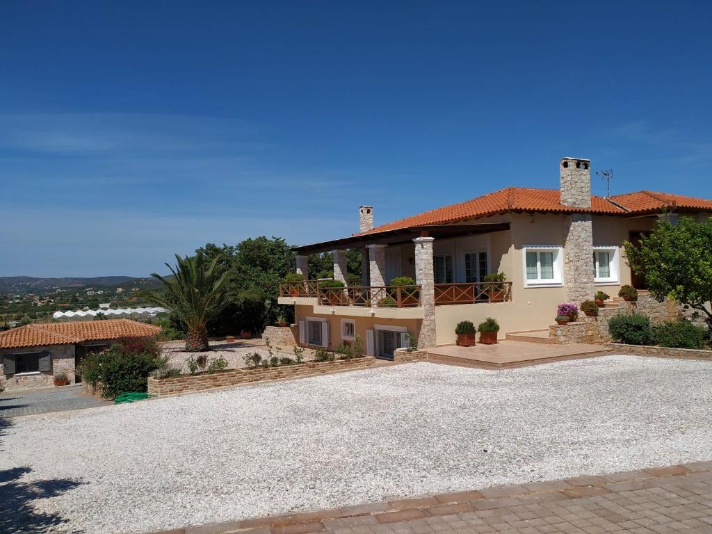 uma casa grande com uma entrada em frente em Villa Vena em Palaiá Fókaia