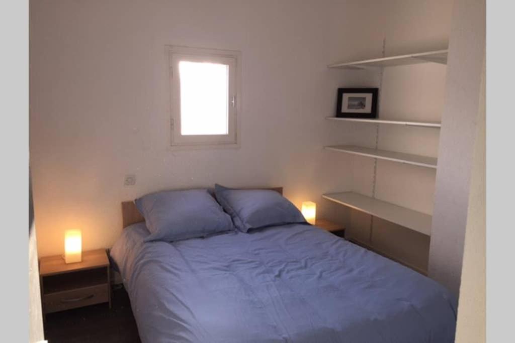 une chambre avec un lit avec deux lampes et une fenêtre dans l'établissement 2 chambres, Résidence avec Piscine, 100 mètres de la mer, à Argelès-sur-Mer