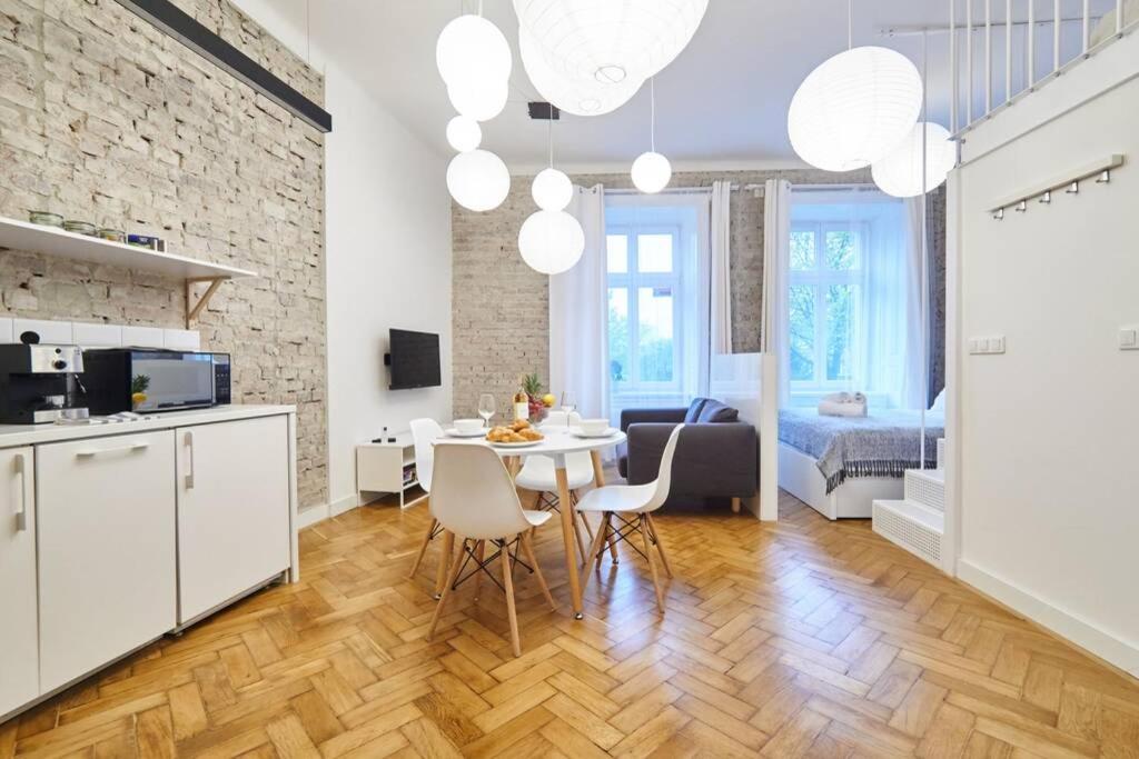 a kitchen and a living room with a table and chairs at Unique Brick 2 - Old Town & Market Square in Kraków