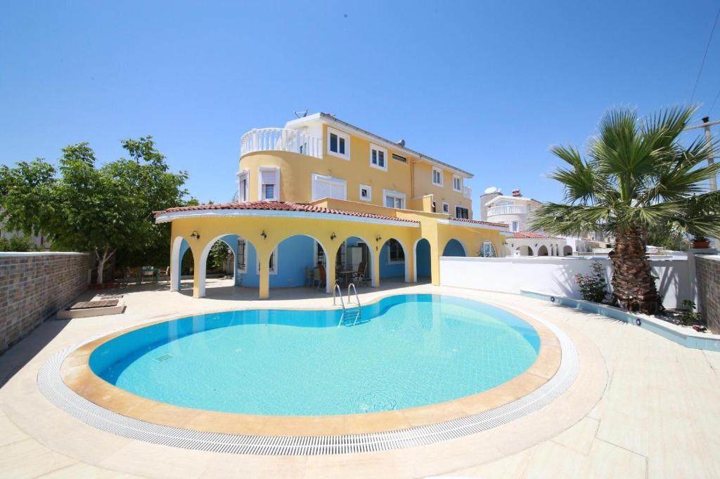 a villa with a swimming pool in front of a house at Fairways villa in Belek