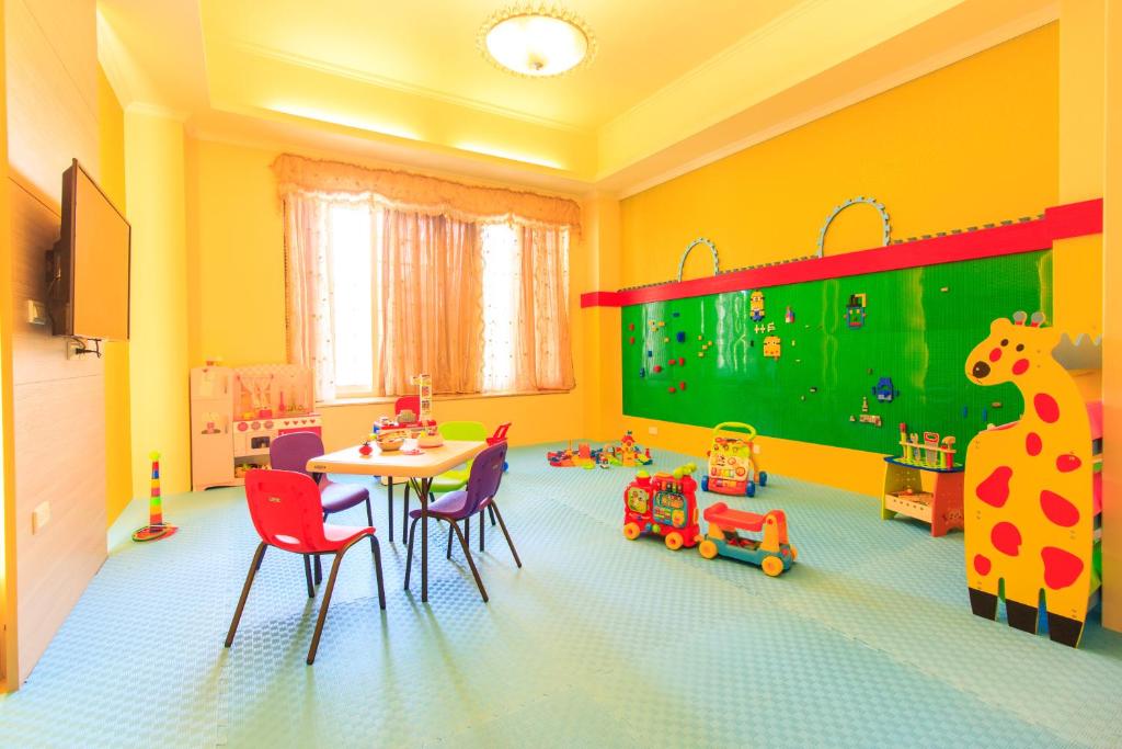 a childs room with a table and chairs and toys at Elegance House in Wujie