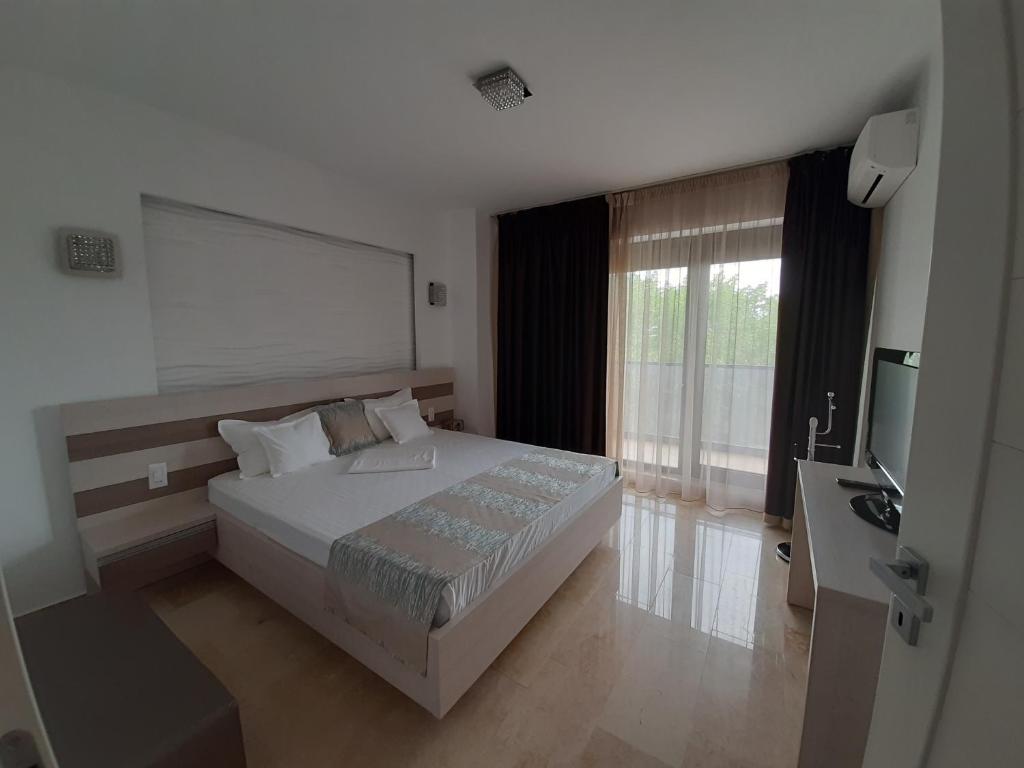 a bedroom with a large bed and a television at Apartament Sebastian - Vila Sophia 3 Mamaia in Mamaia