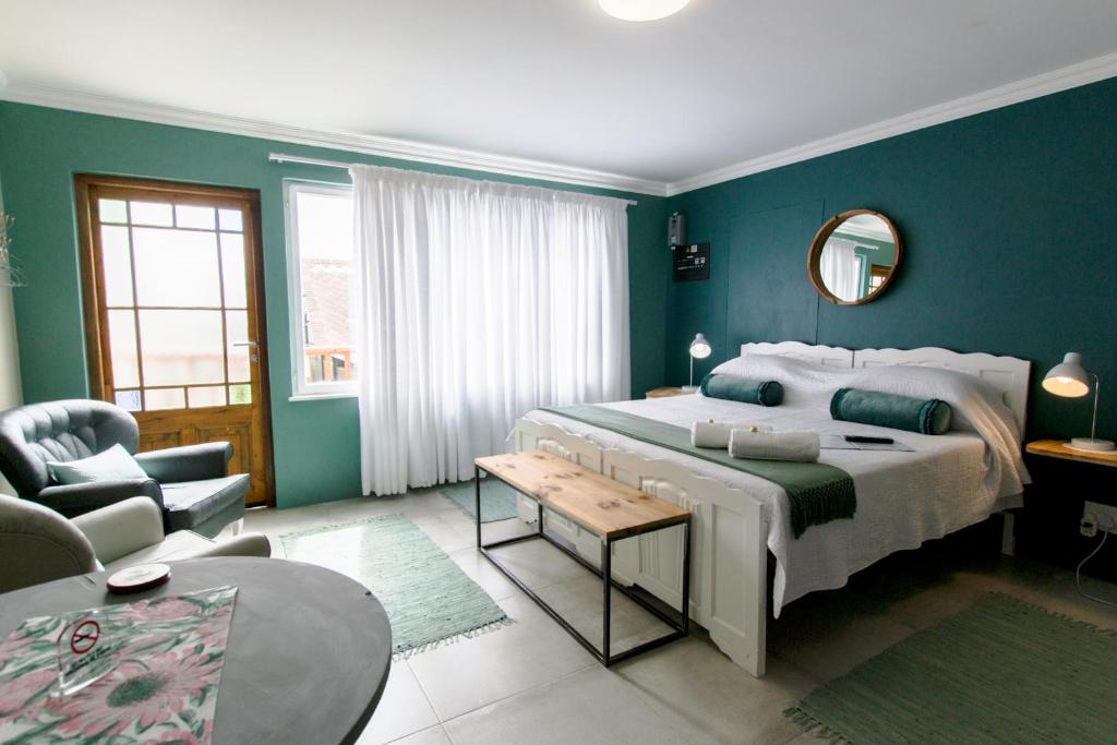 スワコプムントにあるNamibia Nights Accommodationの青い壁のベッドルーム1室(大型ベッド1台付)