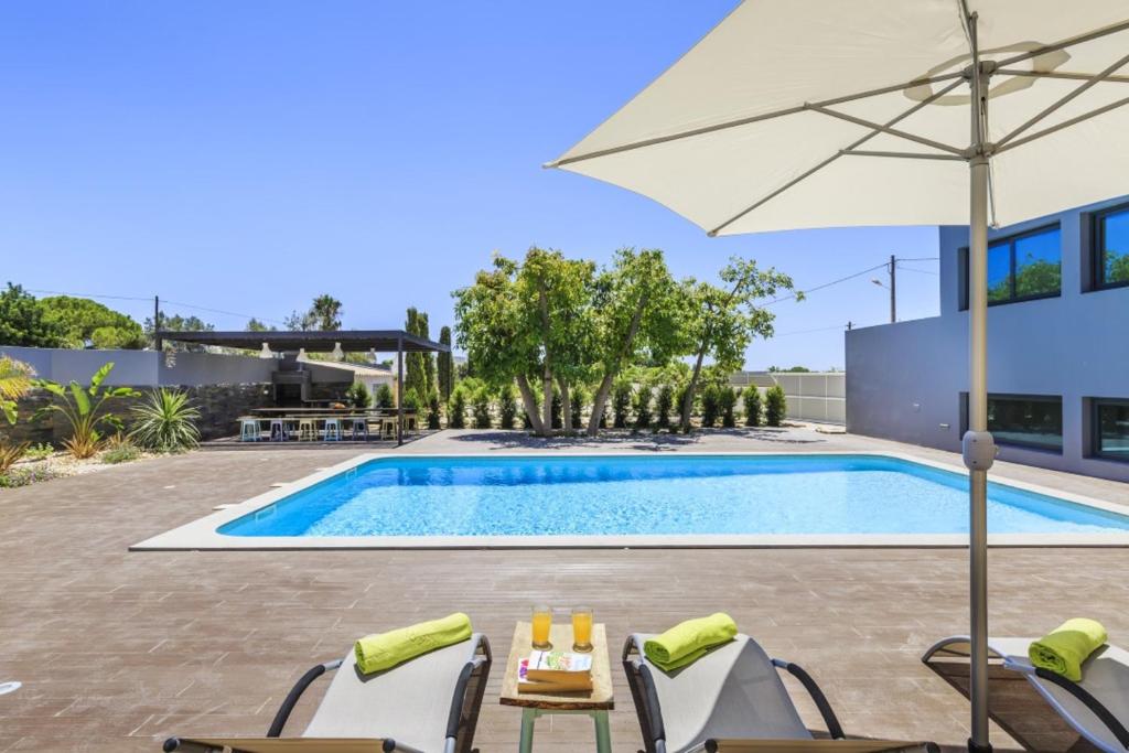 Piscine de l'établissement 3 bedrooms villa with sea view shared pool and enclosed garden at Quelfes 4 km away from the beach ou située à proximité
