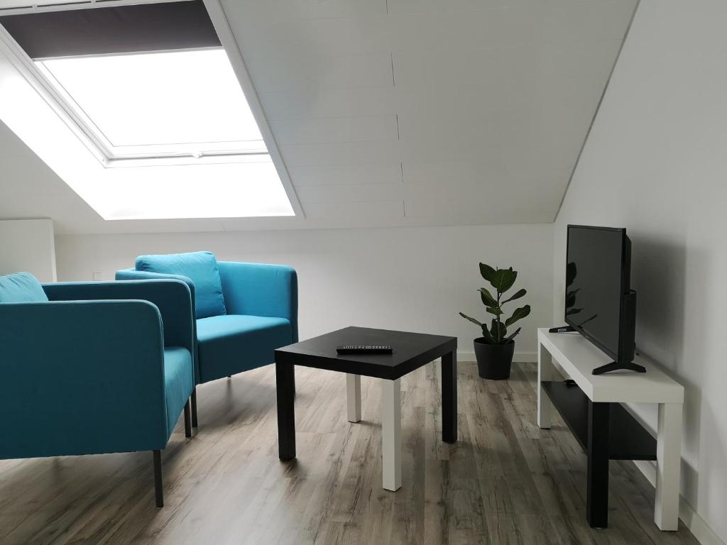 a living room with a couch and a tv and a table at Ferienwohnung Noli in Tuttlingen