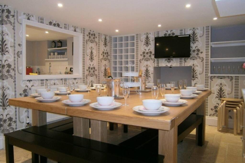 a large wooden table with bowls and plates on it at Parisien Parfumerie in Brighton & Hove