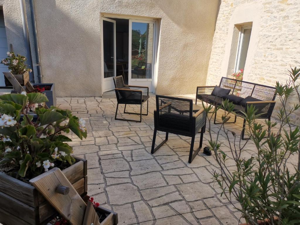 eine Terrasse mit Stühlen, Tischen und Pflanzen in der Unterkunft L'Arche de la Bonde in Volon