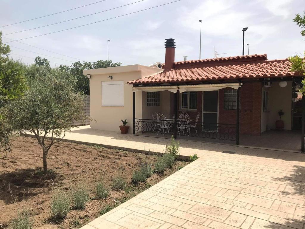 a small house with a porch and a patio at cozy cottage in the suburbs in Kalamata