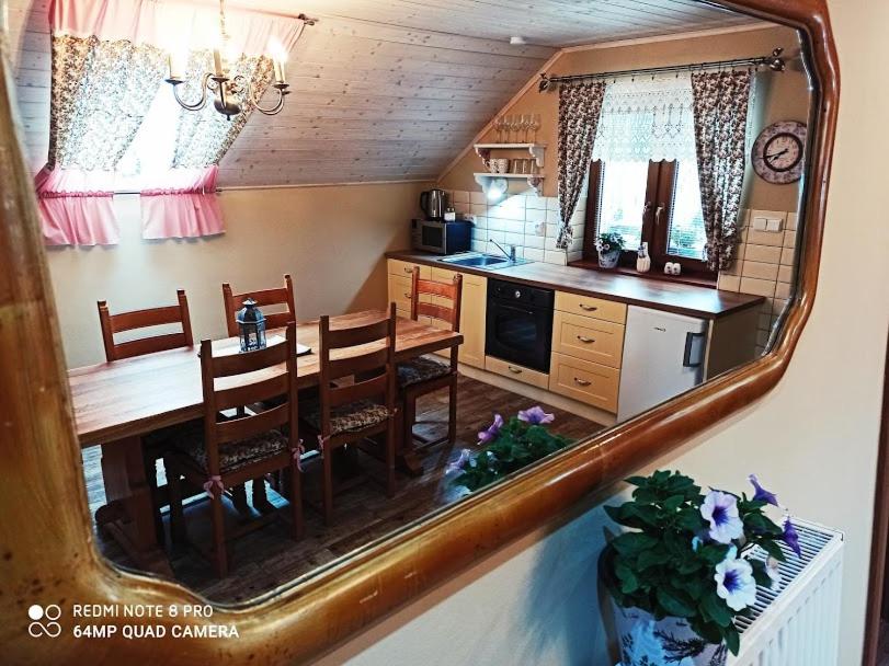 a kitchen with a dining room table and a mirror at Sklípek u Svobodů in Velké Bílovice