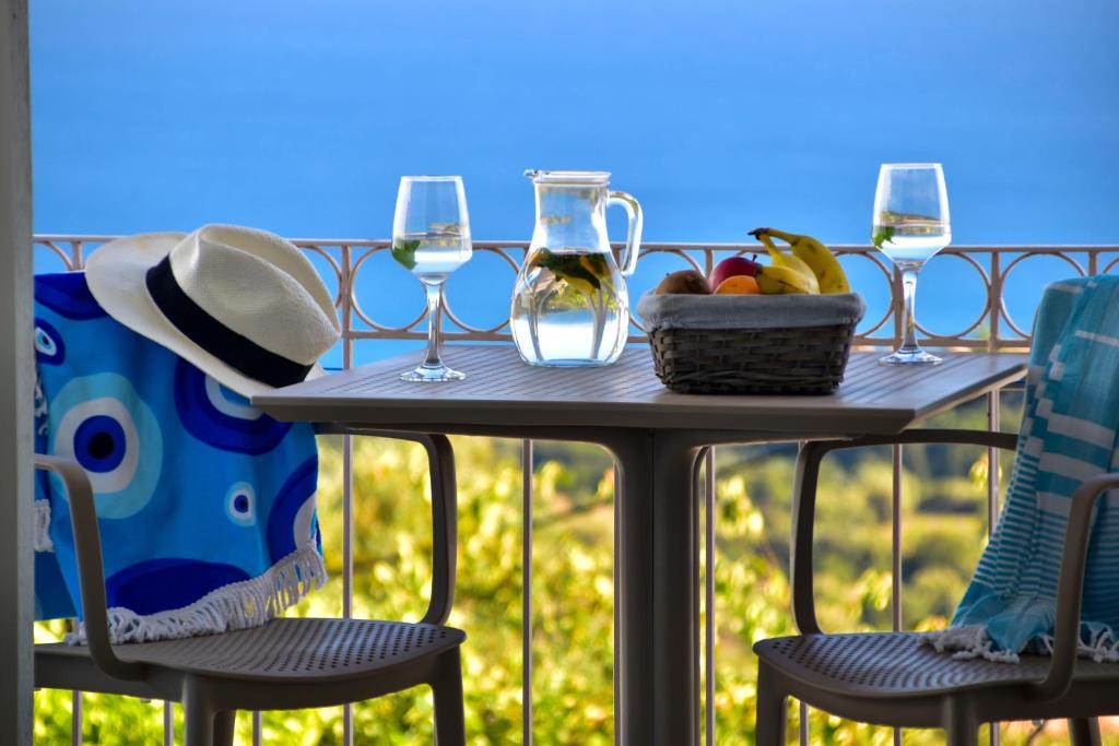 una mesa con copas de vino y una cesta de fruta en Liogerma Studios, en Trapezaki