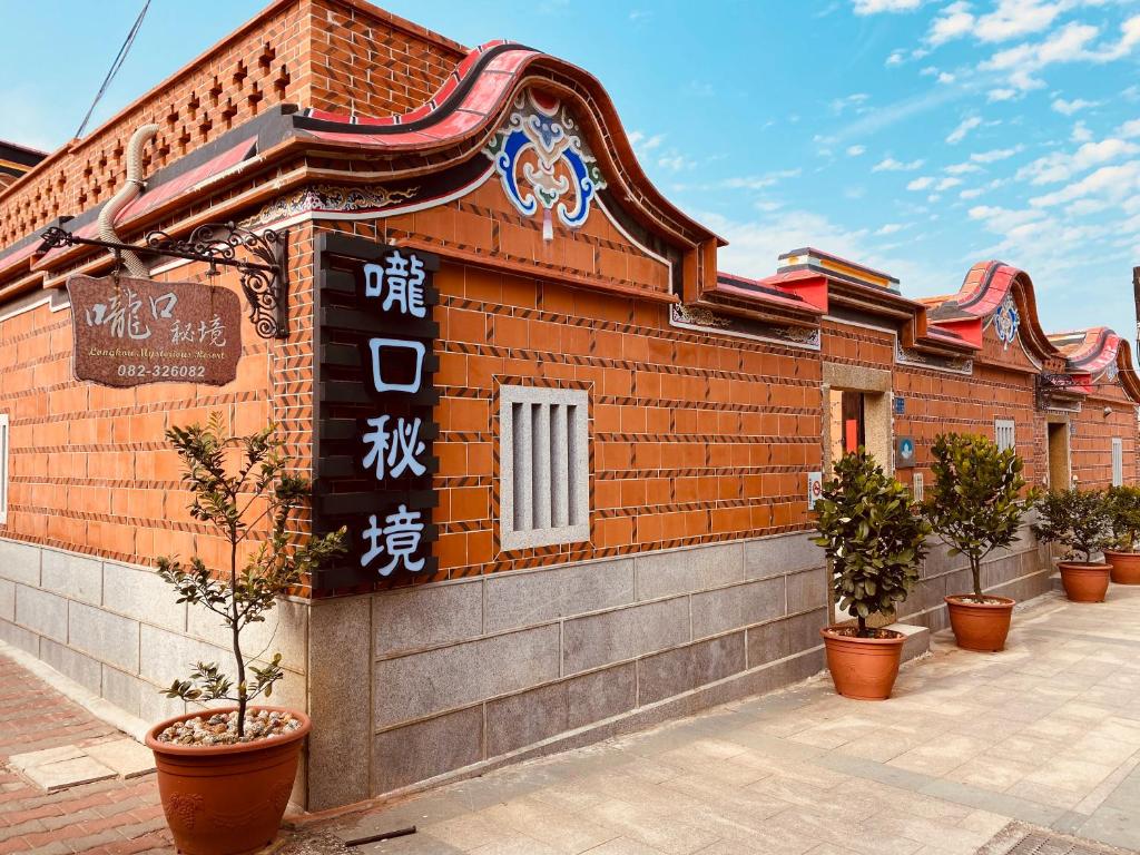 un edificio con un cartel en el costado en 嚨口秘境古厝民宿Longkou Mysterious Resort, en Jinning
