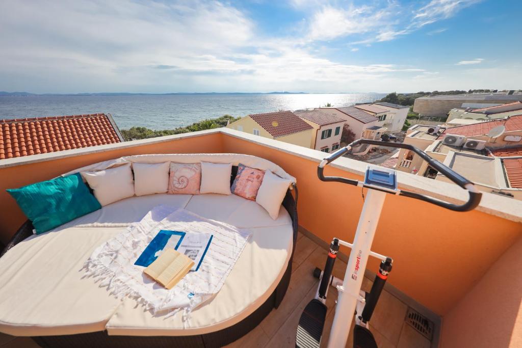 a balcony with a bed and a view of the ocean at Villa Ana in Petrcane