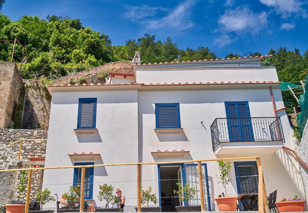 a white house with blue shutters at Maiori Dream House 1 in Maiori