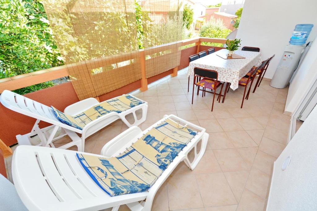 een balkon met stoelen en een tafel en stoelen bij 3 bedrooms appartement at Vir 250 m away from the beach with enclosed garden and wifi in Vir