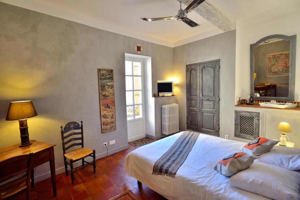 een slaapkamer met een bed, een bureau en een computer bij Le village-hôtes in Sainte-Vallière