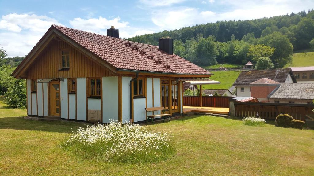 ein kleines Haus auf einem Feld mit Hof in der Unterkunft Ferienhaus Am Kauersberg in Fellen